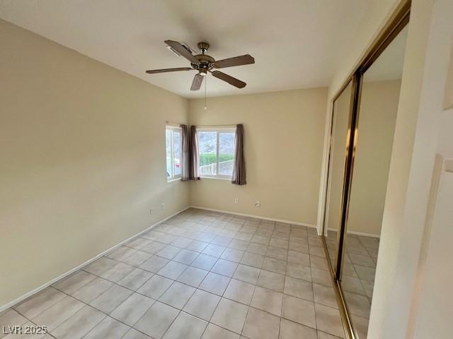 3349 Partridge Run St, Laughlin, NV 89029 - unfurnished bedroom with a closet, light tile patterned floors, baseboards, and a ceiling fan
