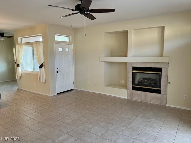 3349 Partridge Run St, Laughlin, NV 89029 - unfurnished living room with a ceiling fan, a tiled fireplace, baseboards, and light tile patterned floors