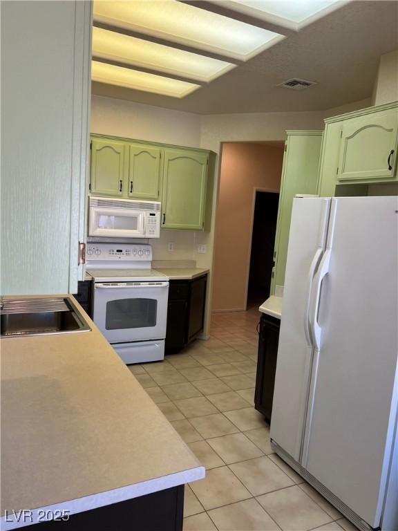 3349 Partridge Run St, Laughlin, NV 89029 - kitchen with green cabinets, white appliances, light countertops, and a sink