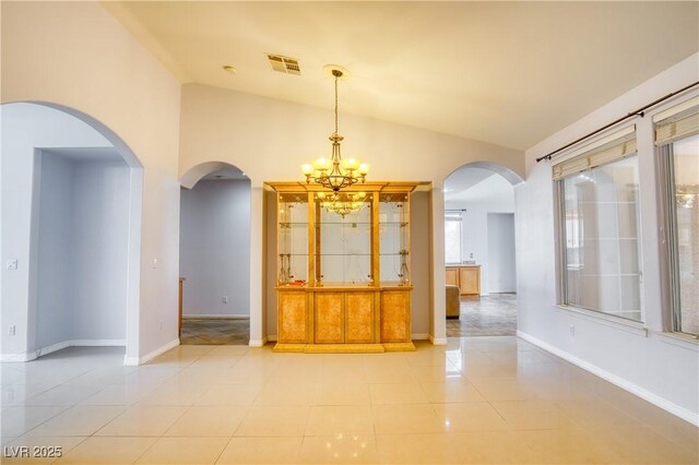 2383 Rainswept Ave, Henderson, NV 89052 - empty room with a chandelier, baseboards, light tile patterned floors, vaulted ceiling, and visible vents