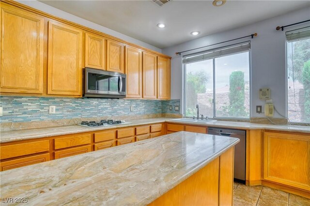 2383 Rainswept Ave, Henderson, NV 89052 - kitchen with light tile patterned flooring, light stone countertops, appliances with stainless steel finishes, a sink, and backsplash