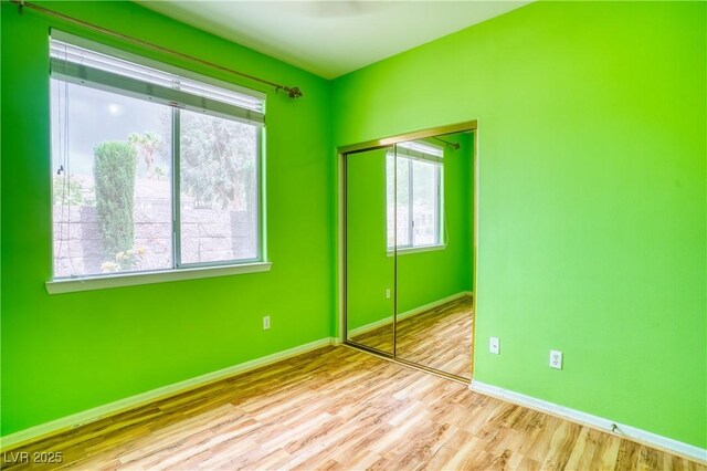 2383 Rainswept Ave, Henderson, NV 89052 - unfurnished bedroom featuring baseboards, a closet, and wood finished floors