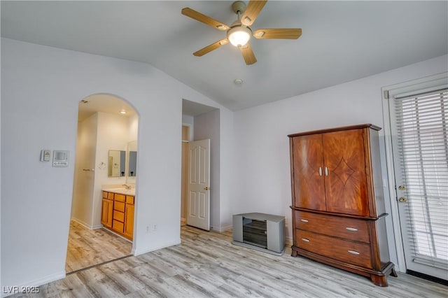 2383 Rainswept Ave, Henderson, NV 89052 - unfurnished bedroom featuring baseboards, arched walkways, light wood finished floors, ensuite bath, and vaulted ceiling