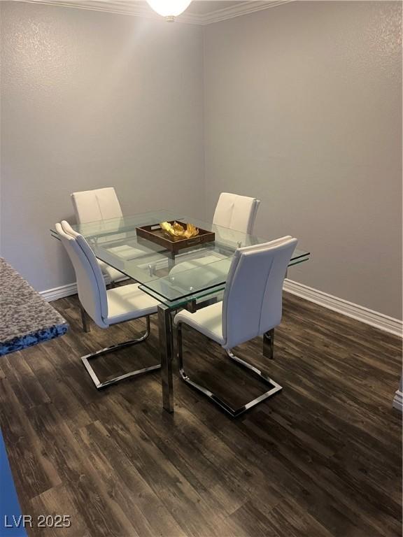 dining area featuring baseboards, ornamental molding, and wood finished floors