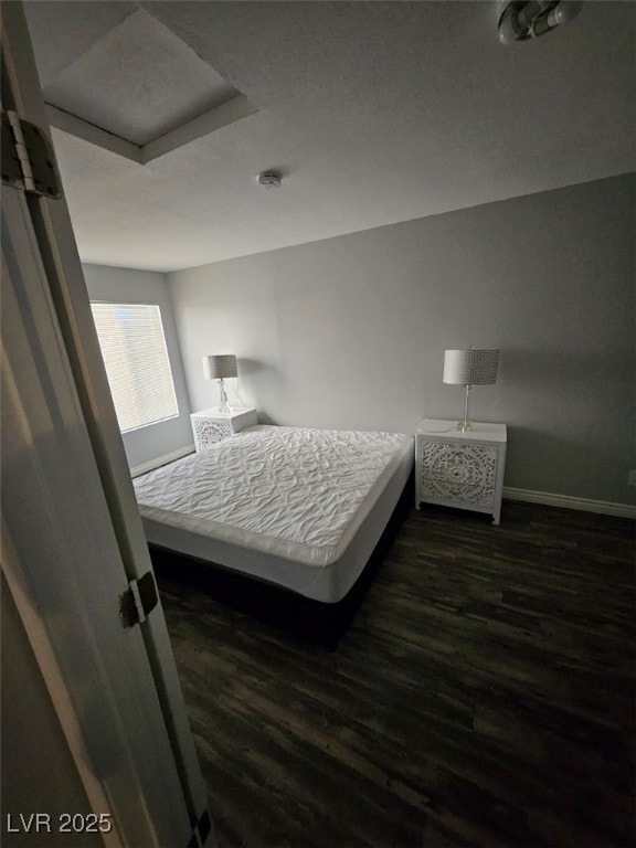 bedroom featuring dark wood-style flooring and baseboards