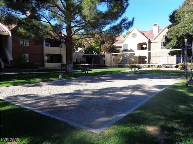 surrounding community with volleyball court and a lawn
