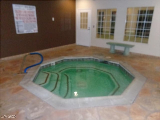view of swimming pool with an indoor hot tub and a pool