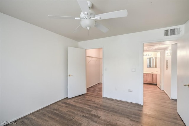 5710 E Tropicana Ave Unit 1017, Las Vegas, NV 89122 - unfurnished bedroom featuring a spacious closet, a closet, visible vents, and wood finished floors