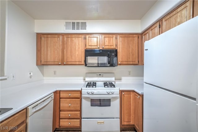 5710 E Tropicana Ave Unit 1017, Las Vegas, NV 89122 - kitchen with brown cabinetry, white appliances, light countertops, and visible vents