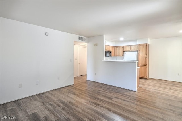 5710 E Tropicana Ave Unit 1017, Las Vegas, NV 89122 - unfurnished living room with recessed lighting, light wood-style flooring, and visible vents
