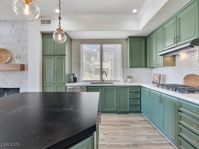 kitchen featuring green cabinets, visible vents, a sink, crown molding, and appliances with stainless steel finishes