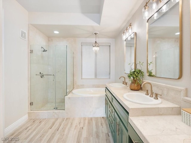 full bathroom with a stall shower, a garden tub, and a sink