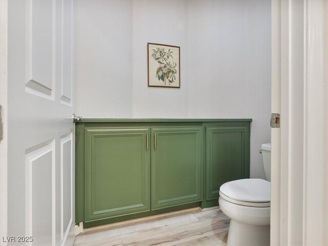 bathroom with toilet and wood finished floors