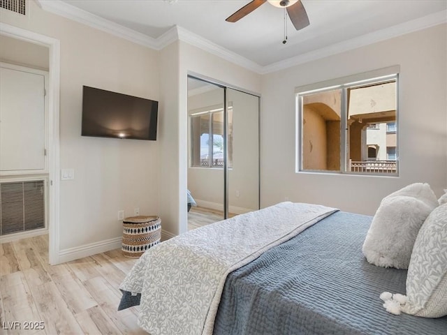 bedroom with ornamental molding, baseboards, visible vents, and wood finished floors