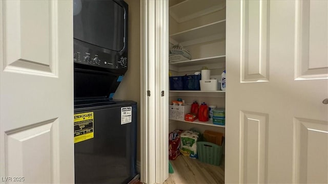 pantry featuring stacked washer and clothes dryer