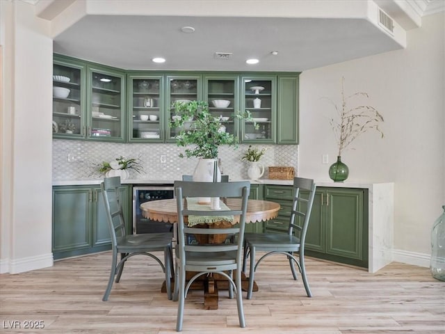 bar with recessed lighting, light wood-style floors, baseboards, and backsplash