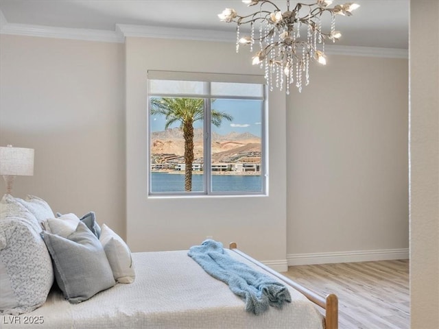 bedroom featuring a chandelier, crown molding, baseboards, and wood finished floors