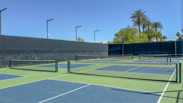 view of tennis court featuring fence and community basketball court