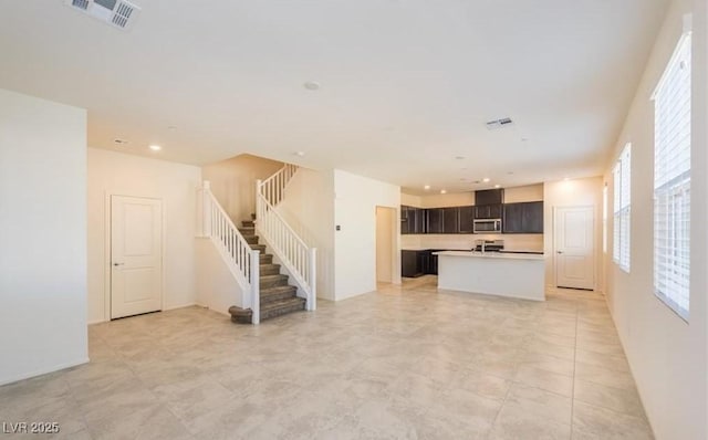 unfurnished living room featuring recessed lighting, stairway, and visible vents