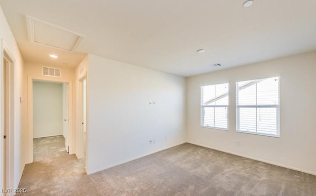 spare room with visible vents, baseboards, and light carpet