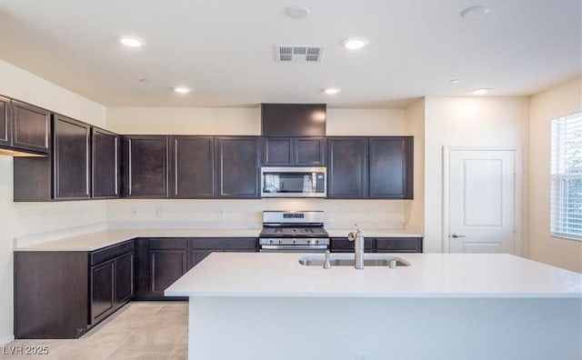 kitchen with a sink, stainless steel appliances, visible vents, light countertops, and dark brown cabinets