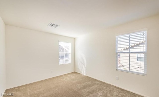 carpeted spare room with baseboards and visible vents