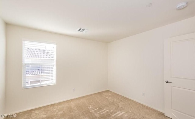 unfurnished room featuring light colored carpet, plenty of natural light, visible vents, and baseboards