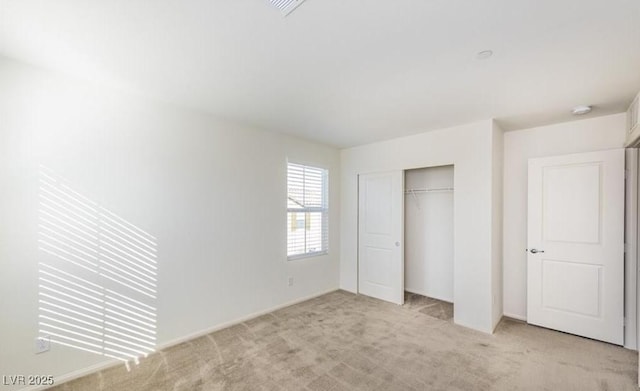 unfurnished bedroom featuring baseboards, a closet, and light colored carpet