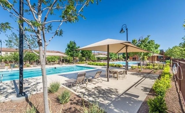 community pool featuring fence and a patio