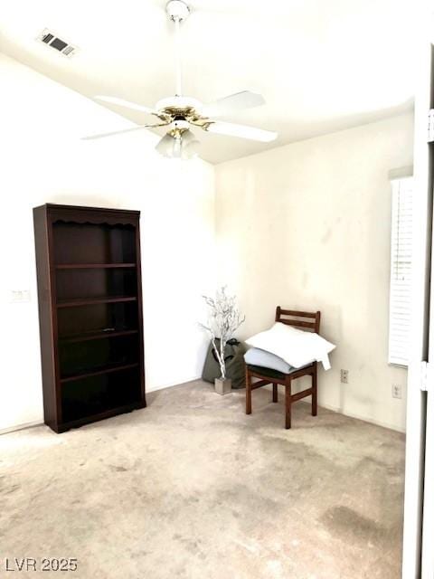 living area with visible vents, a ceiling fan, and carpet floors