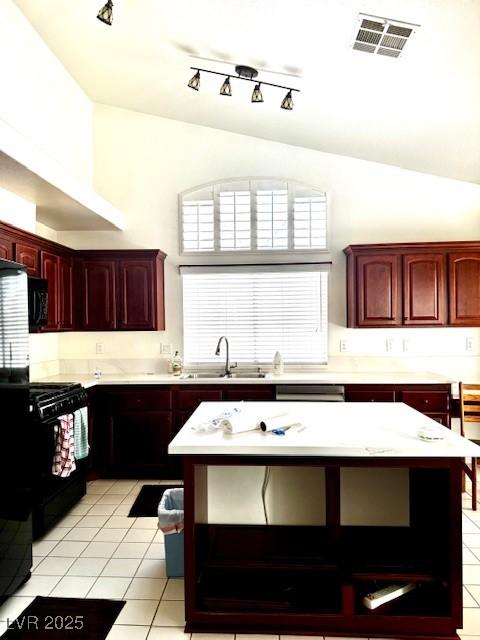 kitchen with a sink, light tile patterned flooring, black appliances, visible vents, and dark brown cabinets