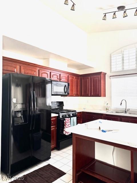 kitchen featuring dark brown cabinets, a sink, rail lighting, black appliances, and light countertops