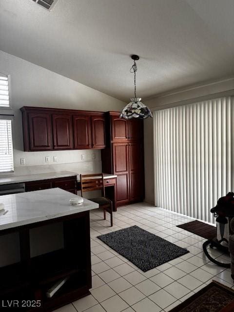 kitchen featuring dark brown cabinets, pendant lighting, visible vents, lofted ceiling, and light tile patterned flooring