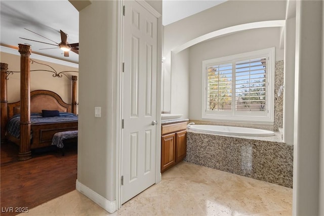 ensuite bathroom with a garden tub, a ceiling fan, ensuite bathroom, vanity, and ornamental molding