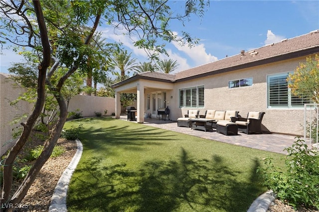 rear view of house with a yard, a patio, stucco siding, a fenced backyard, and an outdoor hangout area