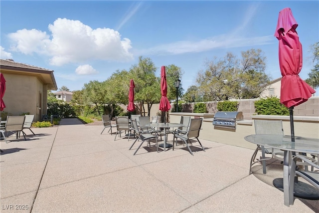view of patio with a fenced backyard, an outdoor kitchen, outdoor dining area, and grilling area
