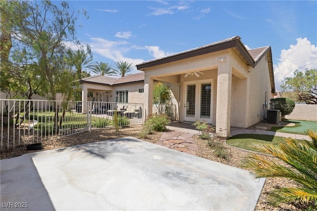 rear view of property featuring a patio, stucco siding, ceiling fan, and fence