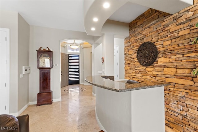 interior space featuring arched walkways, baseboards, and recessed lighting