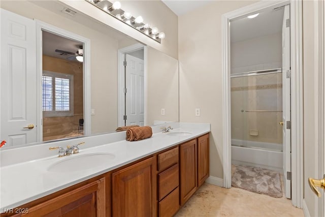 bathroom featuring double vanity, enclosed tub / shower combo, tile patterned flooring, and a sink