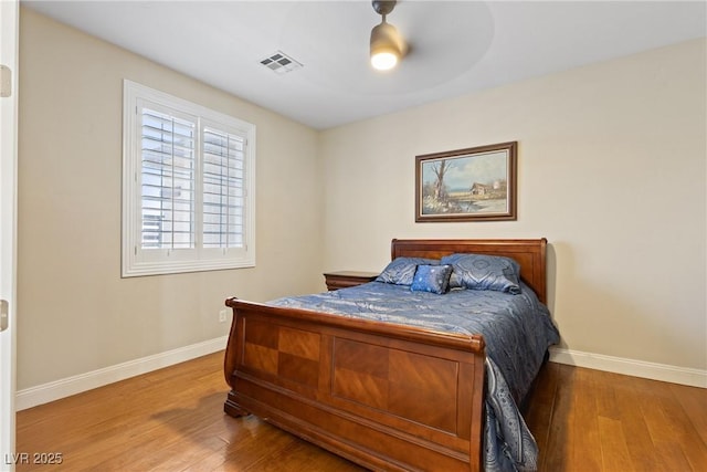 bedroom with visible vents, baseboards, and hardwood / wood-style floors