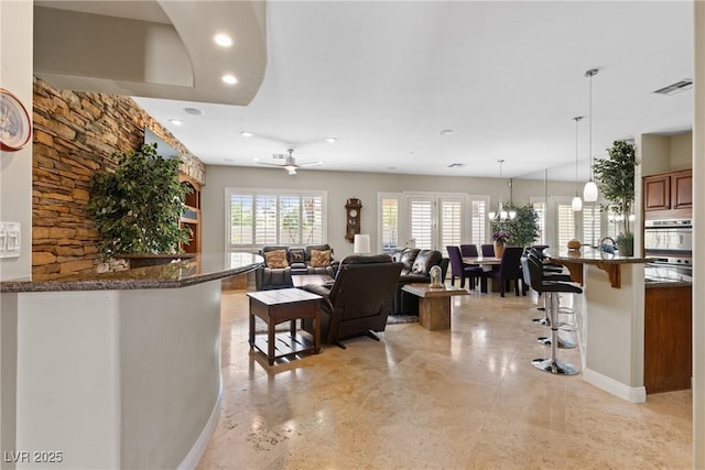 living room with baseboards, visible vents, a chandelier, and recessed lighting