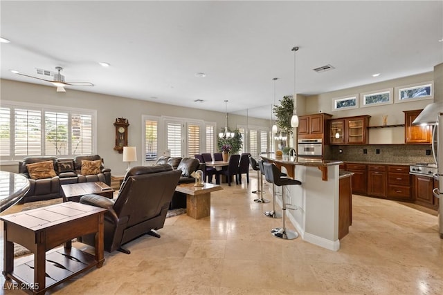 living area featuring recessed lighting, visible vents, and ceiling fan with notable chandelier