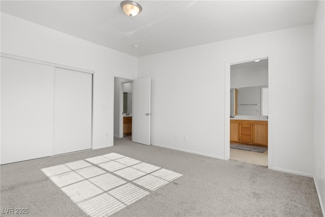4076 Rocky Beach Dr, Las Vegas, NV 89115 - unfurnished bedroom featuring light colored carpet, connected bathroom, a closet, and baseboards