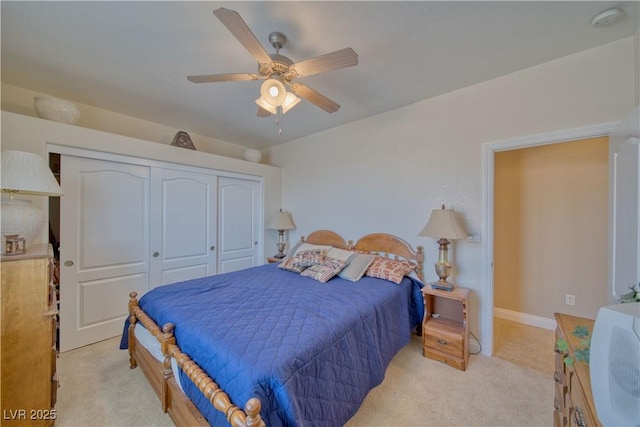 bedroom featuring baseboards, light carpet, a closet, and ceiling fan