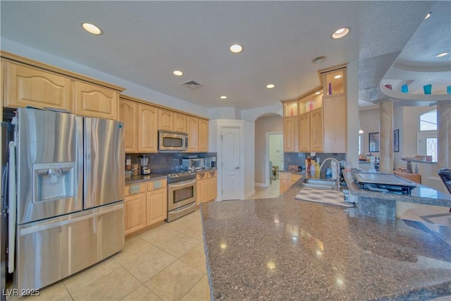 kitchen featuring light brown cabinets, visible vents, a peninsula, and appliances with stainless steel finishes
