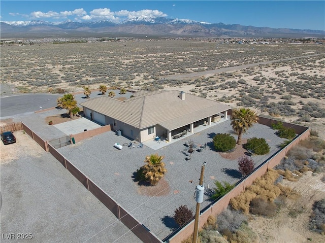 drone / aerial view featuring a mountain view and a desert view