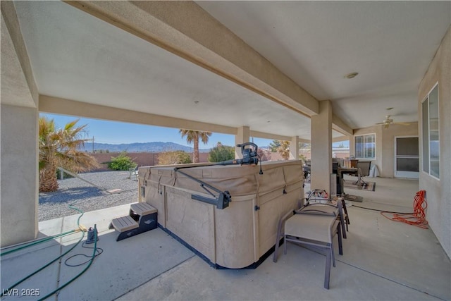view of patio / terrace featuring a mountain view and a hot tub
