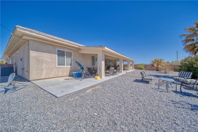 back of house featuring stucco siding, fence, and a patio