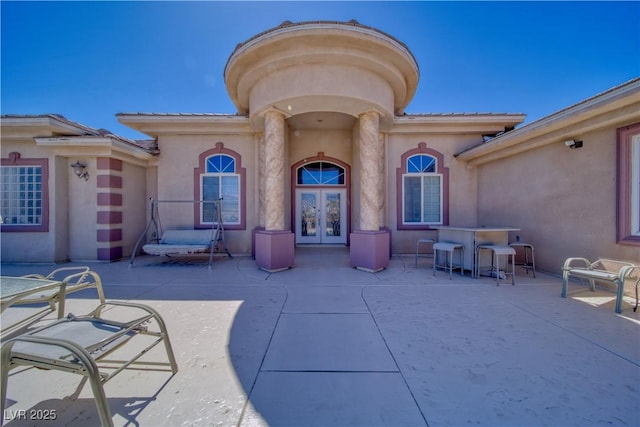 exterior space with a patio area, stucco siding, and french doors