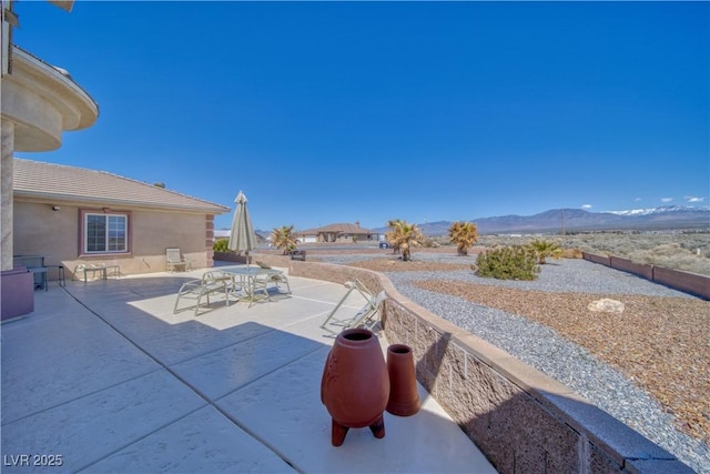 view of patio with a mountain view and outdoor dining space